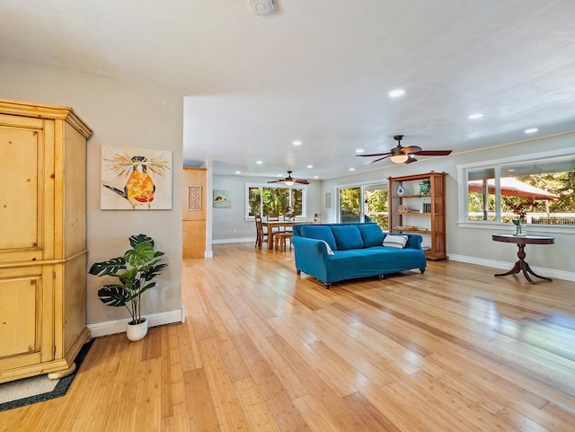 living room featuring light wood-type flooring and ceiling fan