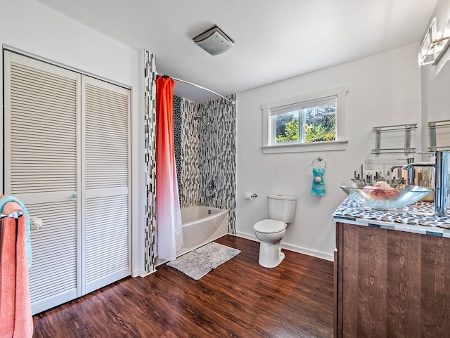 full bathroom featuring shower / bath combination with curtain, hardwood / wood-style floors, toilet, and vanity