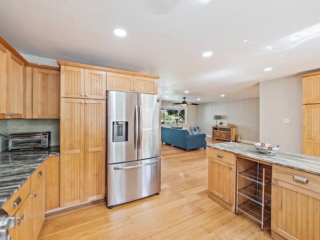 kitchen featuring dark stone counters, ceiling fan, light hardwood / wood-style floors, and stainless steel refrigerator with ice dispenser