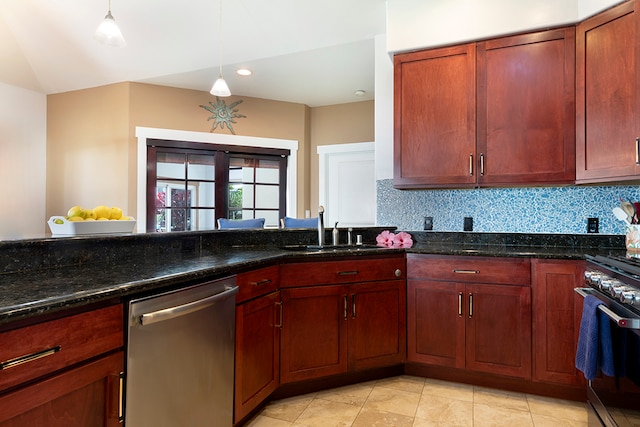 kitchen with decorative backsplash, stainless steel appliances, dark stone countertops, sink, and decorative light fixtures