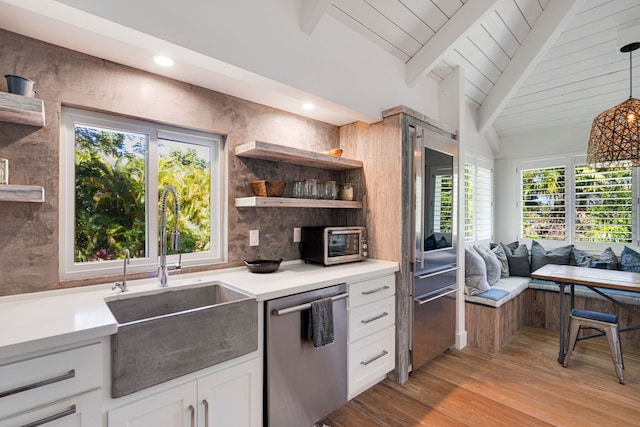 kitchen featuring a healthy amount of sunlight, dishwasher, white cabinets, and hanging light fixtures