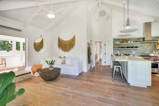 interior space featuring high vaulted ceiling, light hardwood / wood-style flooring, ceiling fan, beam ceiling, and an AC wall unit