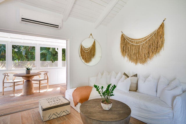 living room featuring lofted ceiling with beams, hardwood / wood-style flooring, and a wall mounted AC