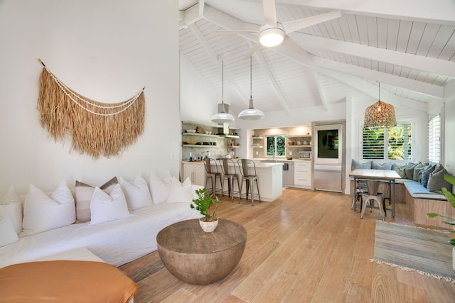 living room with beamed ceiling, high vaulted ceiling, ceiling fan, and light wood-type flooring