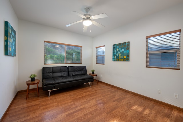 living area featuring hardwood / wood-style floors and ceiling fan