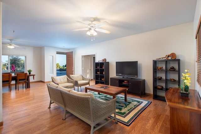 living room with ceiling fan and light hardwood / wood-style flooring