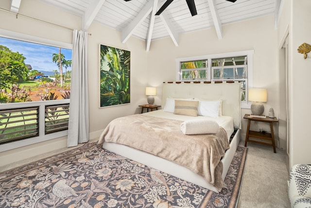 carpeted bedroom featuring vaulted ceiling with beams, multiple windows, and ceiling fan