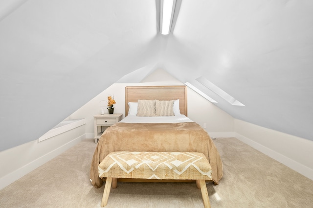 carpeted bedroom featuring vaulted ceiling with skylight