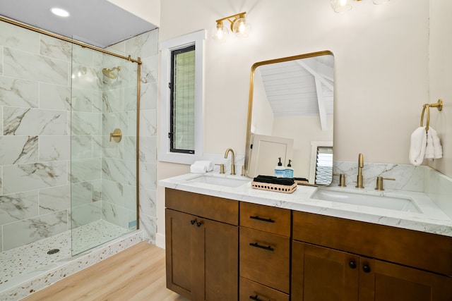 bathroom with dual vanity, a shower with door, lofted ceiling, and hardwood / wood-style flooring