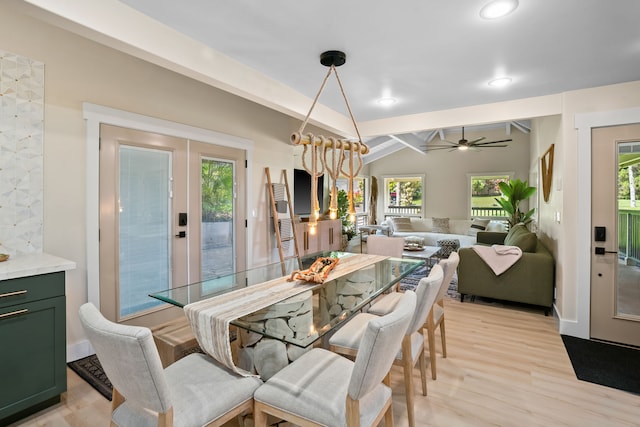 dining space featuring ceiling fan, a healthy amount of sunlight, vaulted ceiling with beams, and light hardwood / wood-style flooring