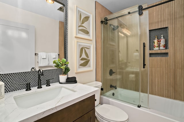 full bathroom featuring combined bath / shower with glass door, toilet, and vanity