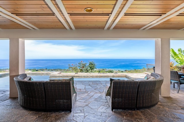 view of terrace with an outdoor living space and a water view