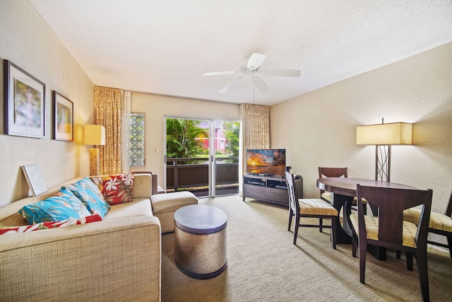 carpeted living room featuring a textured ceiling, a ceiling fan, and a textured wall