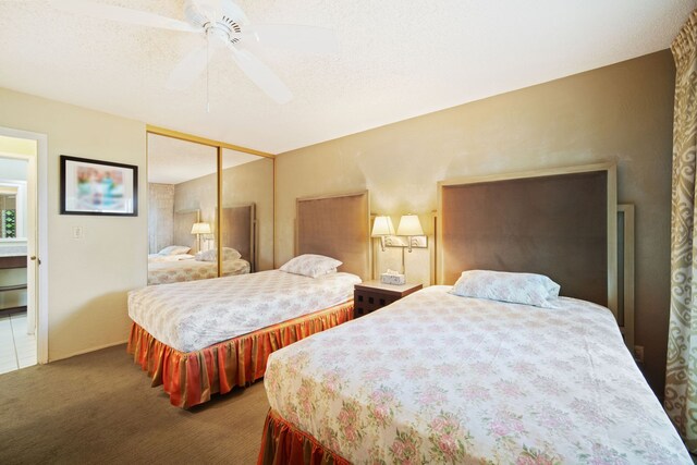 bedroom featuring a textured ceiling, a closet, carpet floors, and ceiling fan