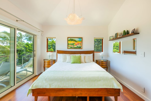 bedroom featuring vaulted ceiling, wood-type flooring, a chandelier, and access to outside