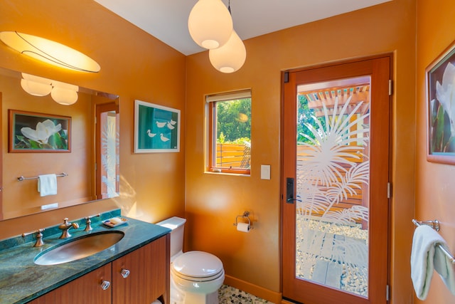 bathroom featuring tile flooring, vanity, and toilet