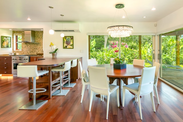 dining room featuring a healthy amount of sunlight, a wall mounted AC, and dark hardwood / wood-style flooring