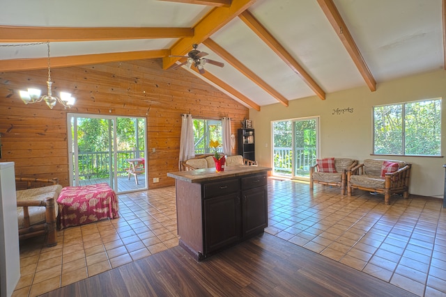 kitchen with tile flooring, high vaulted ceiling, decorative light fixtures, beam ceiling, and wooden walls