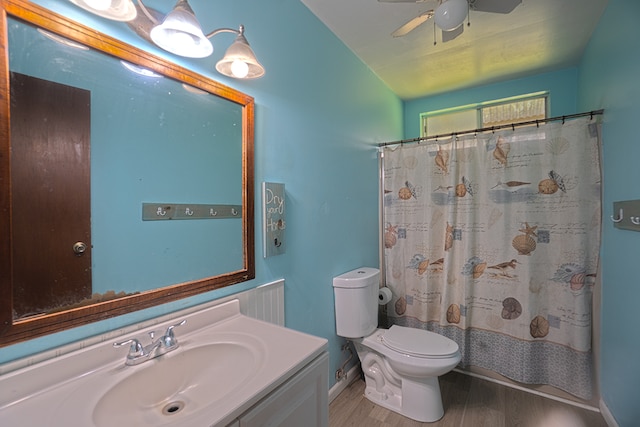 bathroom with ceiling fan, vanity with extensive cabinet space, hardwood / wood-style flooring, and toilet