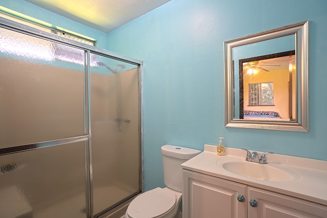 bathroom featuring walk in shower, ceiling fan, toilet, and vanity