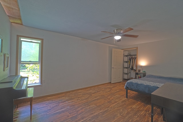 bedroom with a spacious closet, a closet, ceiling fan, and dark hardwood / wood-style floors