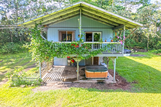 rear view of property featuring a wooden deck and a lawn