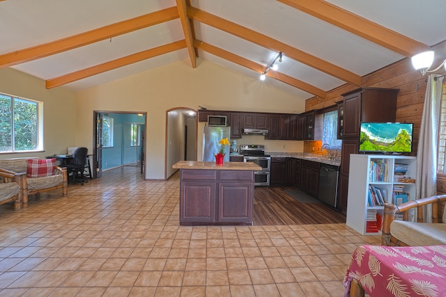 kitchen featuring light tile floors, a kitchen island, dark brown cabinets, beam ceiling, and stainless steel appliances