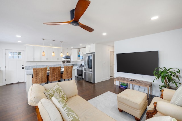 living area with recessed lighting, dark wood-type flooring, and ceiling fan