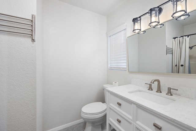 bathroom featuring baseboards, toilet, and vanity