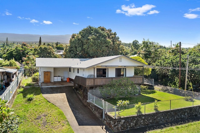 ranch-style home with a fenced front yard, an attached carport, driveway, and a front yard