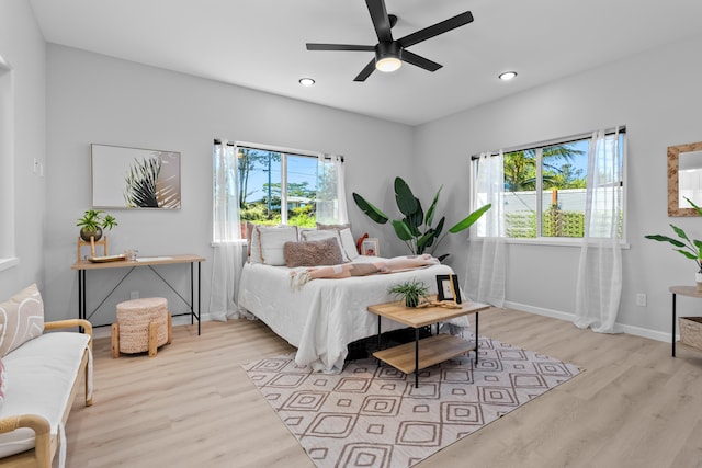 bedroom featuring multiple windows, ceiling fan, and light hardwood / wood-style flooring