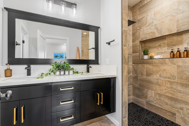 bathroom featuring tiled shower and vanity