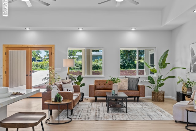 living room with light wood-type flooring, a wealth of natural light, and ceiling fan