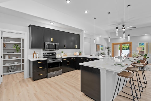 kitchen with pendant lighting, light stone counters, appliances with stainless steel finishes, a kitchen bar, and kitchen peninsula