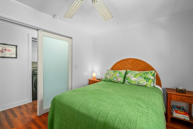 bedroom with washer / clothes dryer, ceiling fan, and dark wood-type flooring