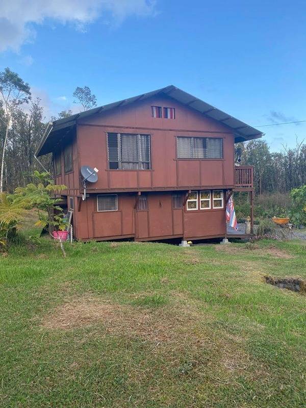 rear view of property featuring a lawn