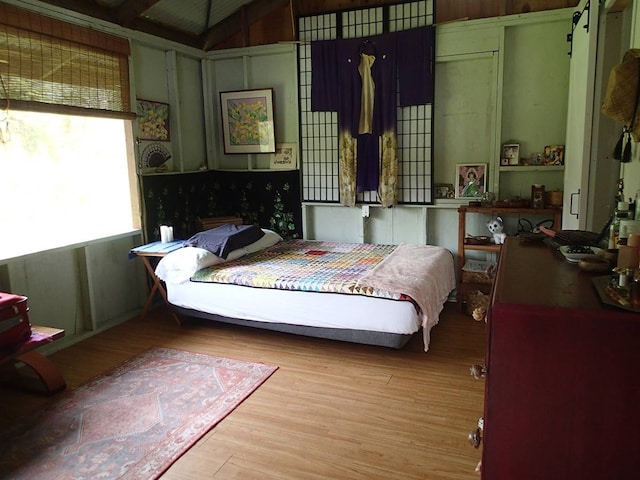 bedroom with vaulted ceiling and light hardwood / wood-style floors