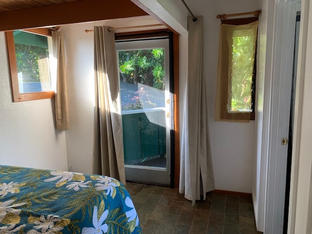 unfurnished bedroom featuring dark tile floors and multiple windows