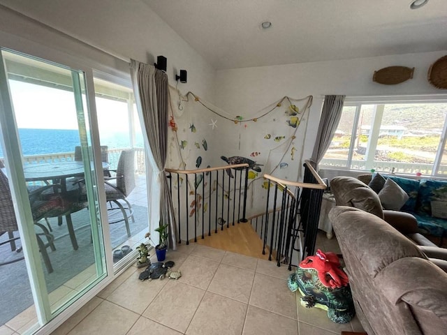 interior space with light tile floors and a water view