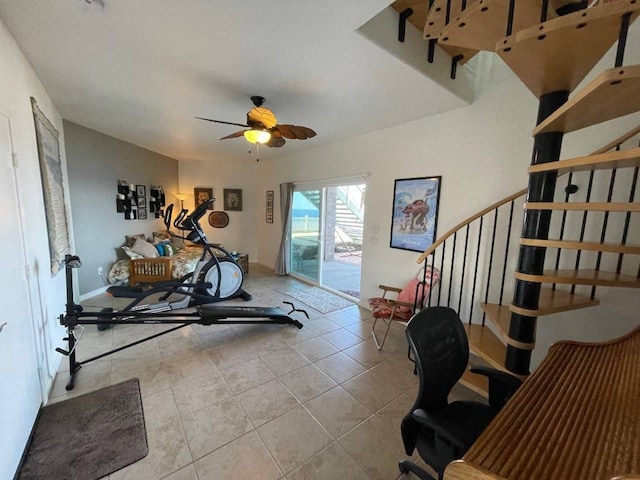 workout area with ceiling fan and tile floors