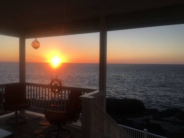 balcony at dusk featuring a water view