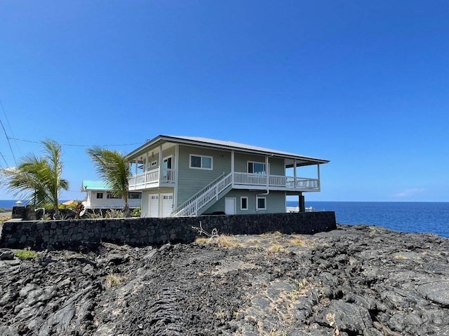 rear view of property featuring a balcony and a water view