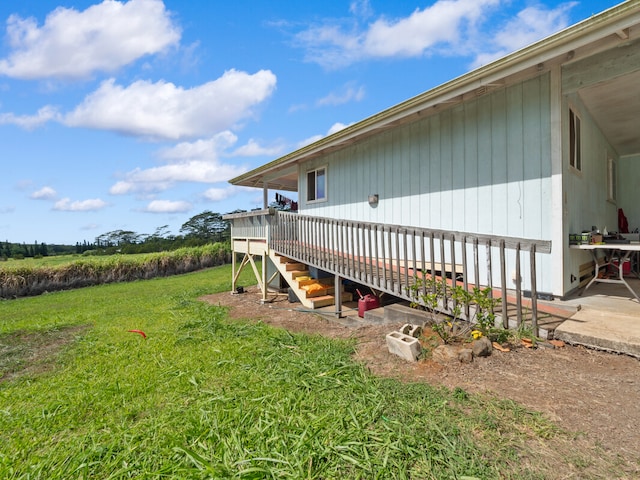 view of home's exterior featuring a wooden deck and a lawn