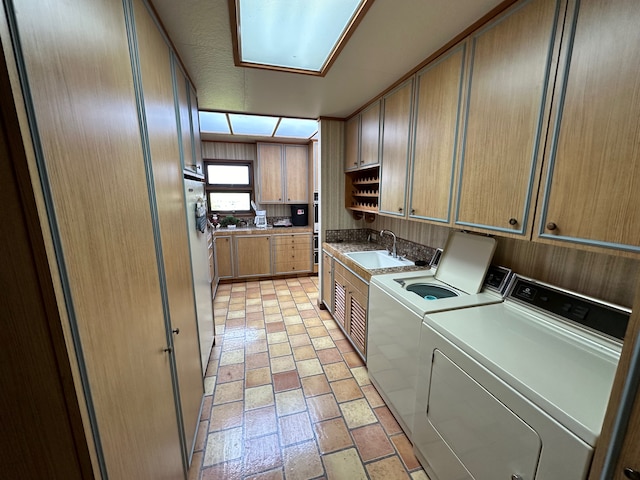 laundry room with cabinets, sink, and washer and clothes dryer