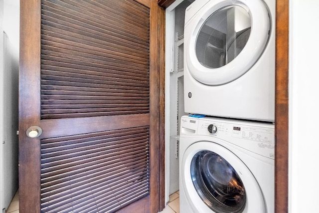 laundry area with laundry area, stacked washing maching and dryer, and light tile patterned flooring