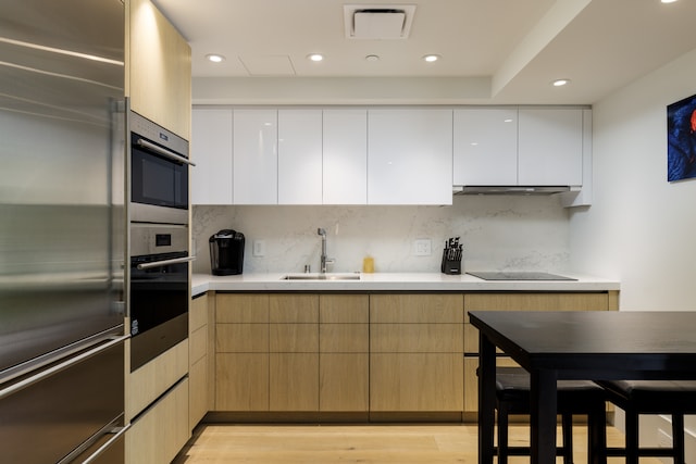 kitchen with white cabinets, sink, light wood-type flooring, and stainless steel appliances