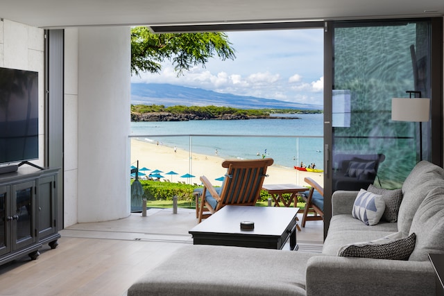 living room with light hardwood / wood-style floors, expansive windows, and a water and mountain view