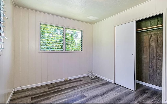 unfurnished bedroom featuring dark wood-type flooring and a closet