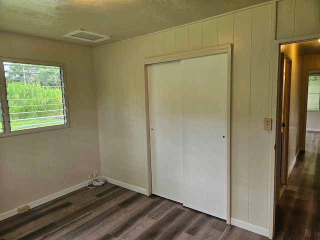 unfurnished bedroom featuring dark hardwood / wood-style floors and a closet