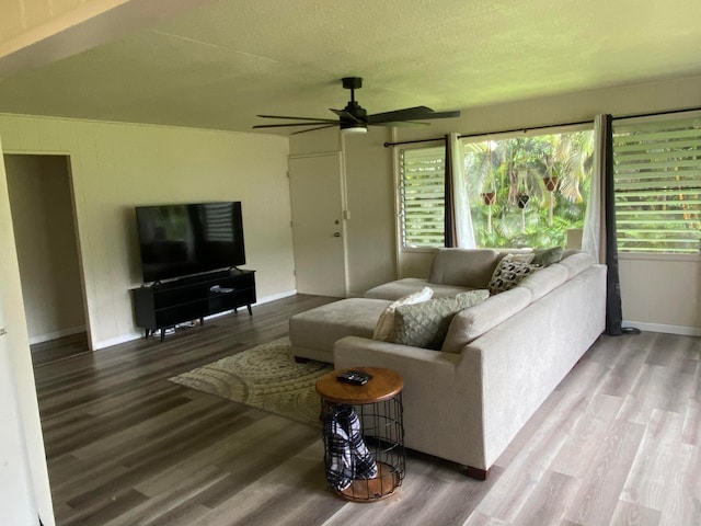 living room with a wealth of natural light, wood-type flooring, and ceiling fan